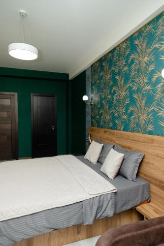 a bedroom with a large bed with green walls at Hotel Graif Ti in Tbilisi City