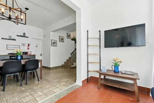 サンファンにあるPr Rentals Walk To La Placita & Condado Beachのテーブルと壁にテレビが置かれたリビングルーム