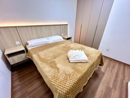 a bedroom with a bed with two towels on it at Apartamento Inteiro - 2 Quartos com AC - Wifi 1000mb - Piscina - 1 Vaga de Garagem - Elevador - Sacada Gourmet - Indicado para Grupos, Hospedes a Trabalho, Família e Pets in Toledo