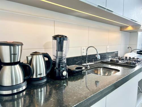 a kitchen counter with a blender and a sink at Apartamento Inteiro - 2 Quartos com AC - Wifi 1000mb - Piscina - 1 Vaga de Garagem - Elevador - Sacada Gourmet - Indicado para Grupos, Hospedes a Trabalho, Família e Pets in Toledo