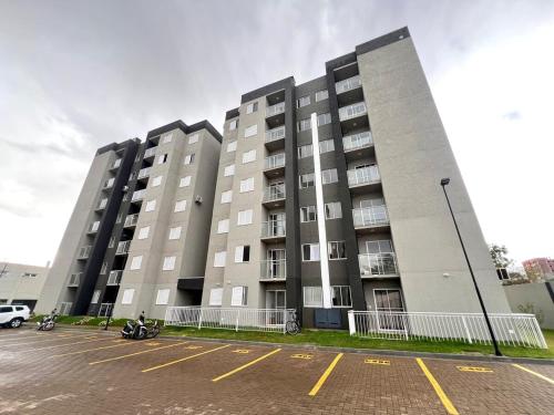a large building with motorcycles parked in a parking lot at Apartamento Inteiro - 2 Quartos com AC - Wifi 1000mb - Piscina - 1 Vaga de Garagem - Elevador - Sacada Gourmet - Indicado para Grupos, Hospedes a Trabalho, Família e Pets in Toledo