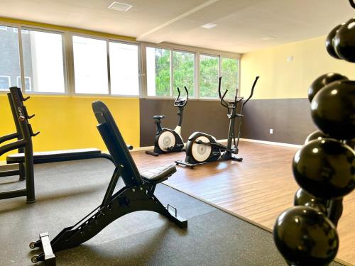 a gym with three exercise bikes in a room at Apartamento Inteiro - 2 Quartos com AC - Wifi 1000mb - Piscina - 1 Vaga de Garagem - Elevador - Sacada Gourmet - Indicado para Grupos, Hospedes a Trabalho, Família e Pets in Toledo