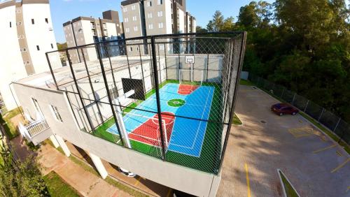 a bird cage with a playground in a parking lot at Apartamento Inteiro - 2 Quartos com AC - Wifi 1000mb - Piscina - 1 Vaga de Garagem - Elevador - Sacada Gourmet - Indicado para Grupos, Hospedes a Trabalho, Família e Pets in Toledo