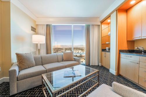 a living room with a couch and a table at Five Star Trump Hotel No Resort and Cleaning Fees in Las Vegas