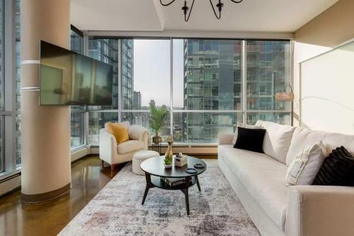 a living room with a white couch and a table at 2Bed DT-Mountain & Skyline Views- Colours 1st-BMO in Calgary
