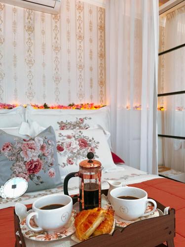 a table with two cups and a tea kettle and toast at Pousada Recanto da Família in Natal