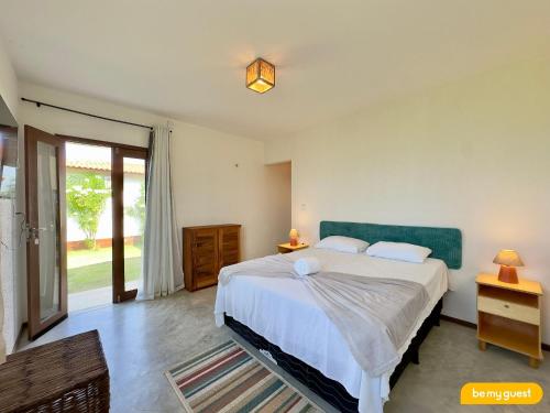 a bedroom with a large bed and a sliding glass door at Reserva BeachFront - Retirinho in Aracati