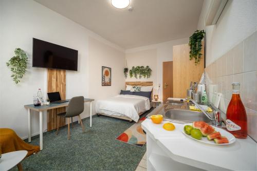 a room with a kitchen and a bedroom with a bed at Ruhiges Studio in Altstadt mit Gartenblick & Sofa in Freiberg