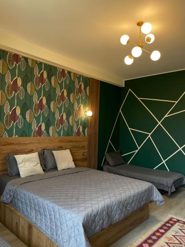 a bedroom with a bed and a green wall at Hotel Graif Ti in Tbilisi City