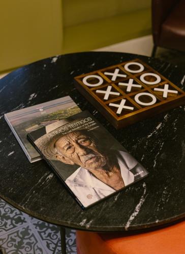a table with a book and a magazine on it at Kahal Hotel - Paseo Montejo in Mérida