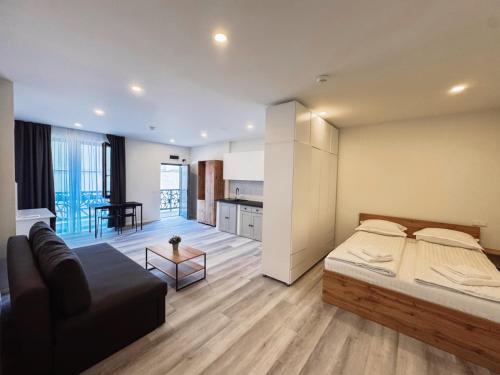 a bedroom with a bed and a living room at Urban76 Apartments in Târgu-Mureş