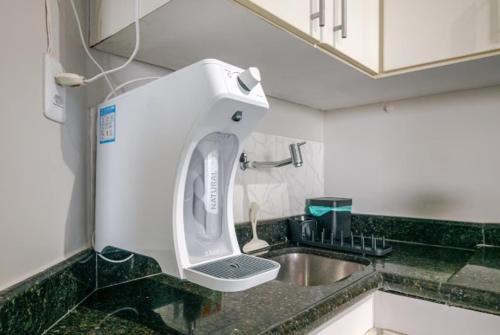 Un secador de pelo está colgado sobre un fregadero en una cocina. en Lindo vista mar na Praia do Buracão - Rio Vermelho, en Salvador