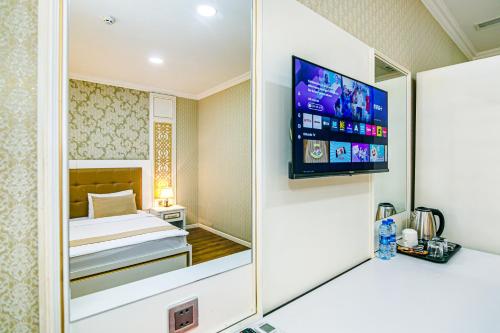 a hotel room with a bed and a tv at Maris Hotel Baku in Baku