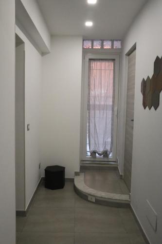 un pasillo vacío con una ventana y una puerta en Henny House, en Catania