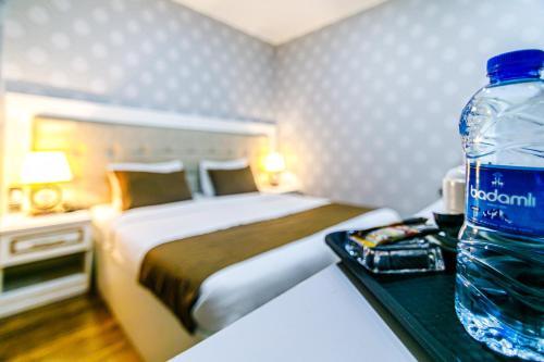 a bottle of water sitting on a table next to a bed at Maris Hotel Baku in Baku