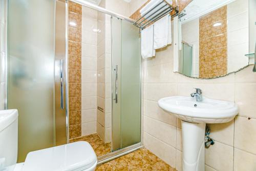 a bathroom with a toilet and a sink and a shower at Maris Hotel Baku in Baku