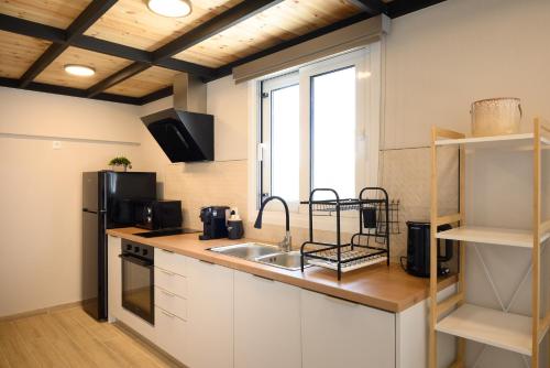 a kitchen with a sink and a microwave at Cestrum Suites in Agios Nikolaos