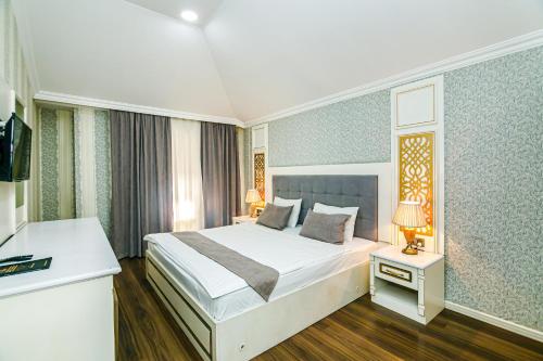 a hotel room with a bed and a television at Maris Hotel Baku in Baku