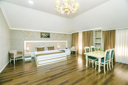 a bedroom with a bed and a table and chairs at Maris Hotel Baku in Baku