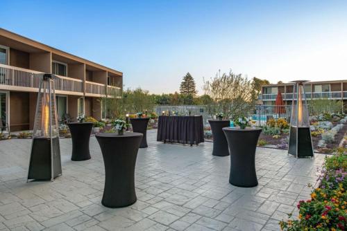 a group of tables with flowers in a courtyard at Holiday Inn Oxnard - Ventura by IHG in Oxnard