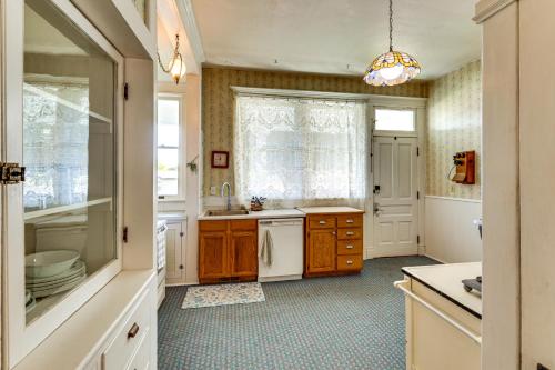 Clarkstonにある2 Mi to River Historic Clarkston Home with Views!の白いキャビネット、シンク、窓付きのキッチン