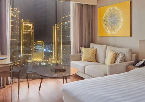 a living room with a couch and a glass table at Novotel Rockwell View Hotel Residences in Manila