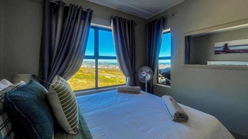 a bedroom with a bed with a large window at Nivica Lifestyle Apartment in Langebaan
