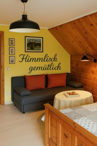 a bedroom with a couch and a sign on the wall at Landhaus Gritschacher in Sankt Peter in Holz