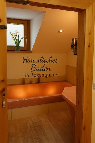 a bench in a bathroom with a sign on the wall at Landhaus Gritschacher in Sankt Peter in Holz