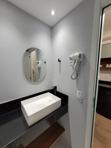 a bathroom with a white sink and a mirror at Studio Tatuapé próximo ao Shopping in São Paulo