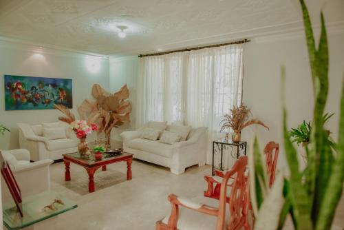 a living room with white couches and a table at Casa Vallenata in Valledupar