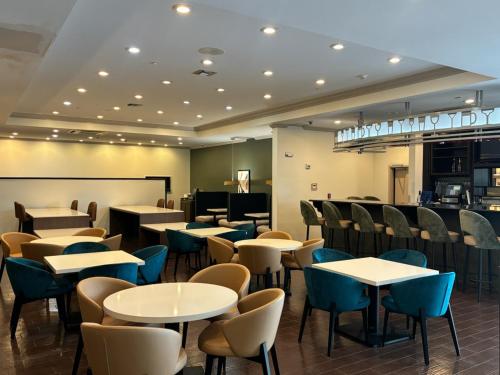 a restaurant with tables and chairs and a bar at Wyndham Lake Charles in Lake Charles