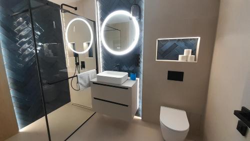une salle de bain avec toilettes, lavabo et miroir dans l'établissement Apartament Centrum, à Nowy Targ