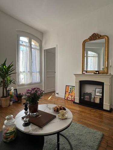 un salon avec une table et un miroir dans l'établissement White Paris, à Paris