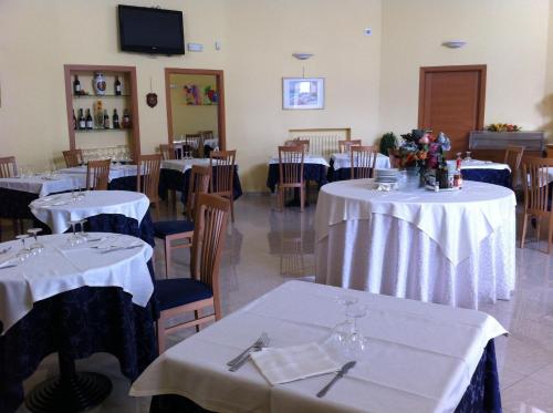 ein Esszimmer mit Tischen und Stühlen sowie weißen Tischdecken in der Unterkunft Hotel Atleti in Foggia