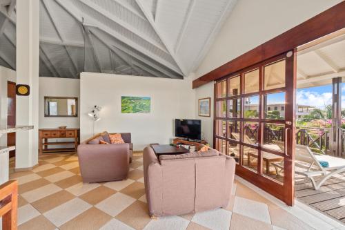 a living room with two chairs and a television at Blue Bay Villa's in Blue Bay