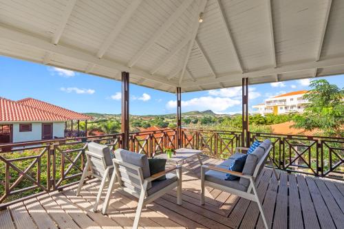 a patio with a table and chairs on a deck at Blue Bay Villa's in Blue Bay