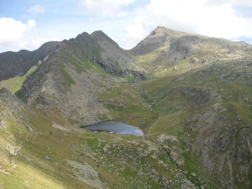 a mountain with a lake in the middle of it at Post Hotel Moena in Moena