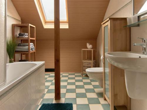 a bathroom with a tub and a toilet and a sink at Haus Freigeist - zum Ortsblick in Neinstedt