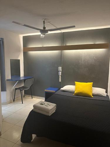 a bedroom with a bed with a yellow pillow and a desk at Vagabundo Expo Guadalajara in Guadalajara
