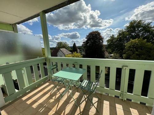 a table and chairs on a balcony with a view at Studio lumineux de 23m avec balcon in Bagnoles de l'Orne