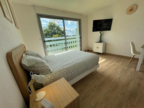a small bedroom with a bed and a window at Studio lumineux de 23m avec balcon in Bagnoles de l'Orne