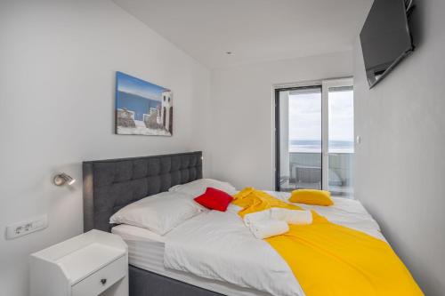 a bedroom with a bed with white and yellow sheets at Villa Eva in Dramalj