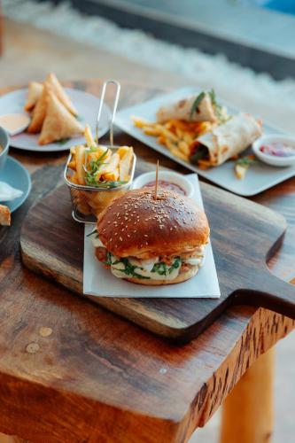 a table with plates of food on a wooden tray at The Bali Resort Zanzibar in Pingwe