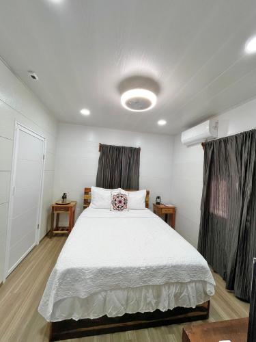 a bedroom with a large white bed with curtains at The Ambassador's Terrace in Belize City