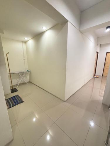 an empty room with white walls and white tile floors at Bulanhome in Sathani Hat Yai