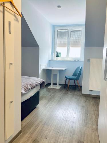 a bedroom with a bed and a desk and a table at Das SinGold Hotel mit Highspeed WLAN und digitalem Schlüssel in Schwabmünchen