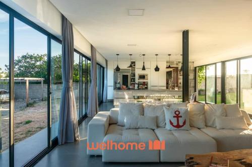 a living room with a white couch and some windows at Suite em Tibau do Sul proxima a praia das Minas in Pipa