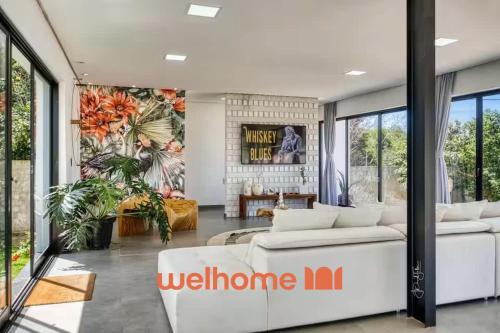 a living room with a white couch and a wall of windows at Suite em Pipa com piscina incrivel em Mansao in Pipa