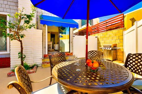 a table with a bowl of fruit and a blue umbrella at Perfect Newport Beach Location With Spa I in Newport Beach